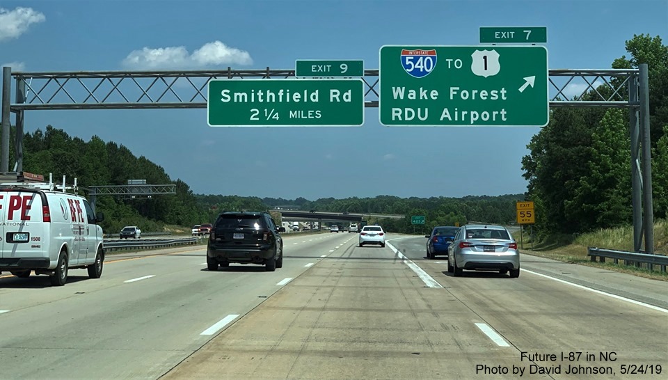 Image of overhead signs with new I-87 exit number tabs at off-ramp to I-540 on I-87 North, US 64/264 East in Knightdale, by David Johnson