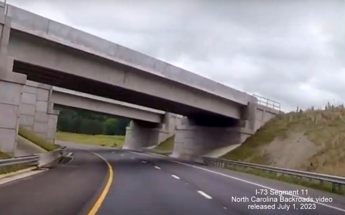 Image of US 74 West traffic heading under future I-73/I-74 bridges constructed as part of
       Rockingham Bypass, video from North Carolina Backroads, July 2023