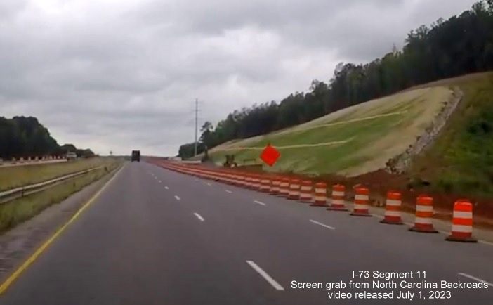 Image of widening being done along US 74 West now after Business 74 on-ramp at end of construction zone for
        interchange with I-73/I-74 Rockingham Bypass, video from North Carolina Backroads, July 2023