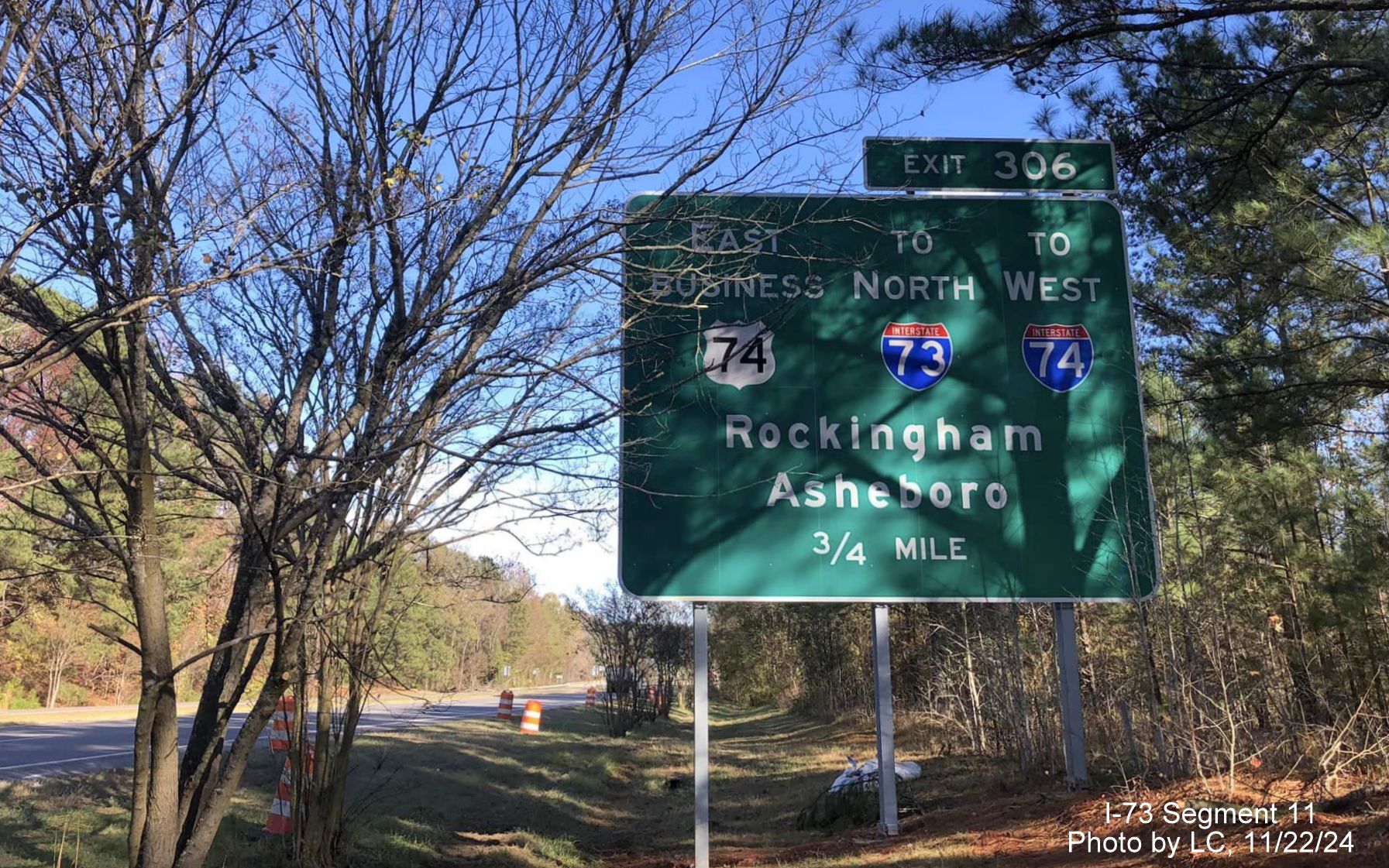 Image of partially hidden 3/4 mile advance signage for the Business 74 and I-73 North/I-74 West
        Rockingham Bypass exit on US 74 East, by LC, November 2024