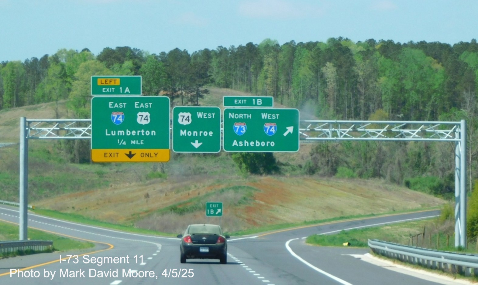 Image of overhead advance signs for I-73/I-74 and I-74/US 74 Rockingham Bypasses
		on US 74 Business West by Mark David Moore, April 2025