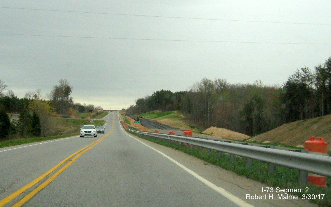 Image of view looking south along current US 220 roadway just after NC 68 intersection showing progress building 
        future I-73 South lanes