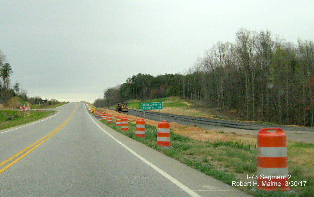 Image of view looking south along current US 220 roadway approaching NC 65 intersection showing progress building new south 
        I-73 lanes