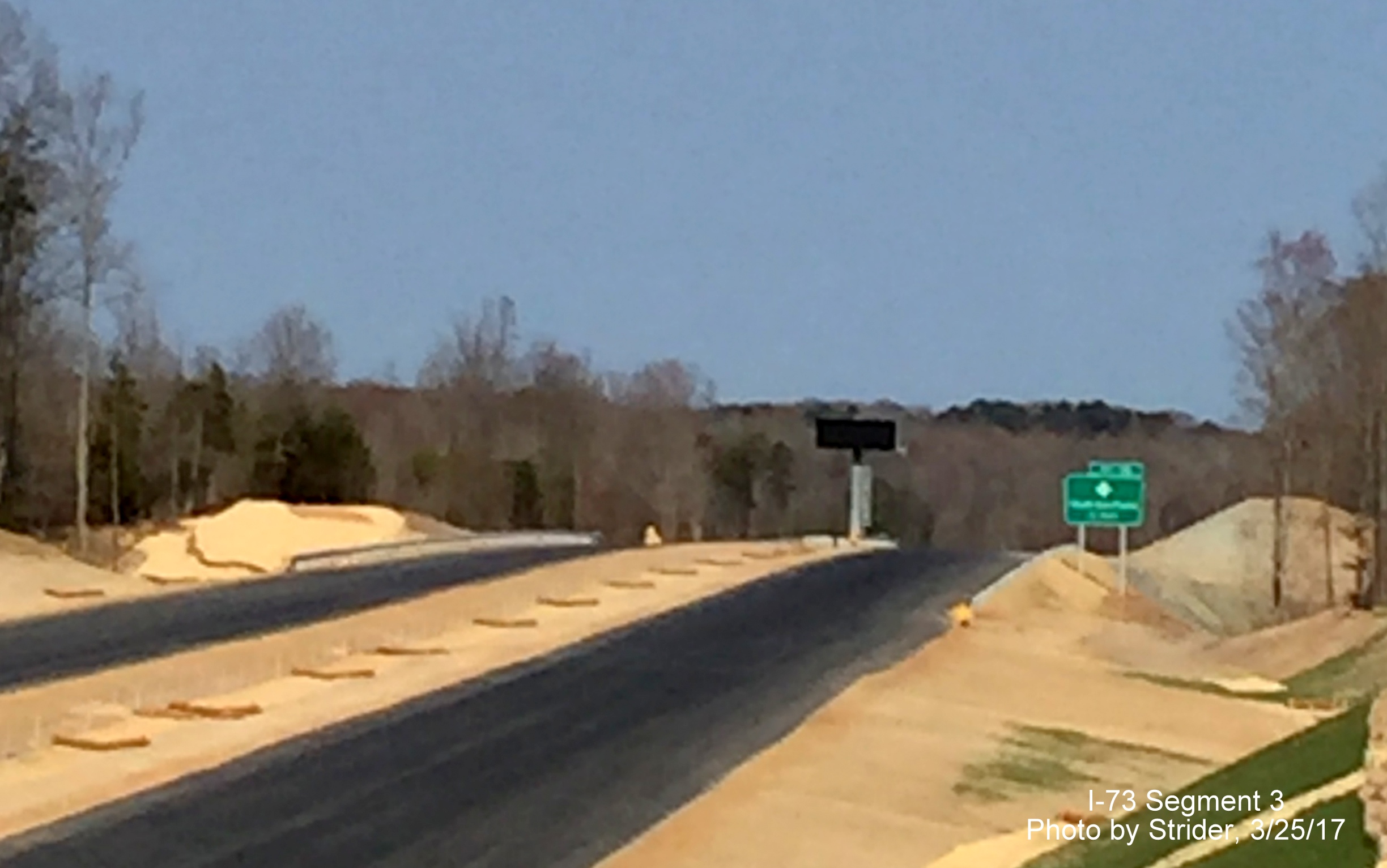 Image of view south from Bunch Rd showing installation of new sign for NC 150 exit, by Strider