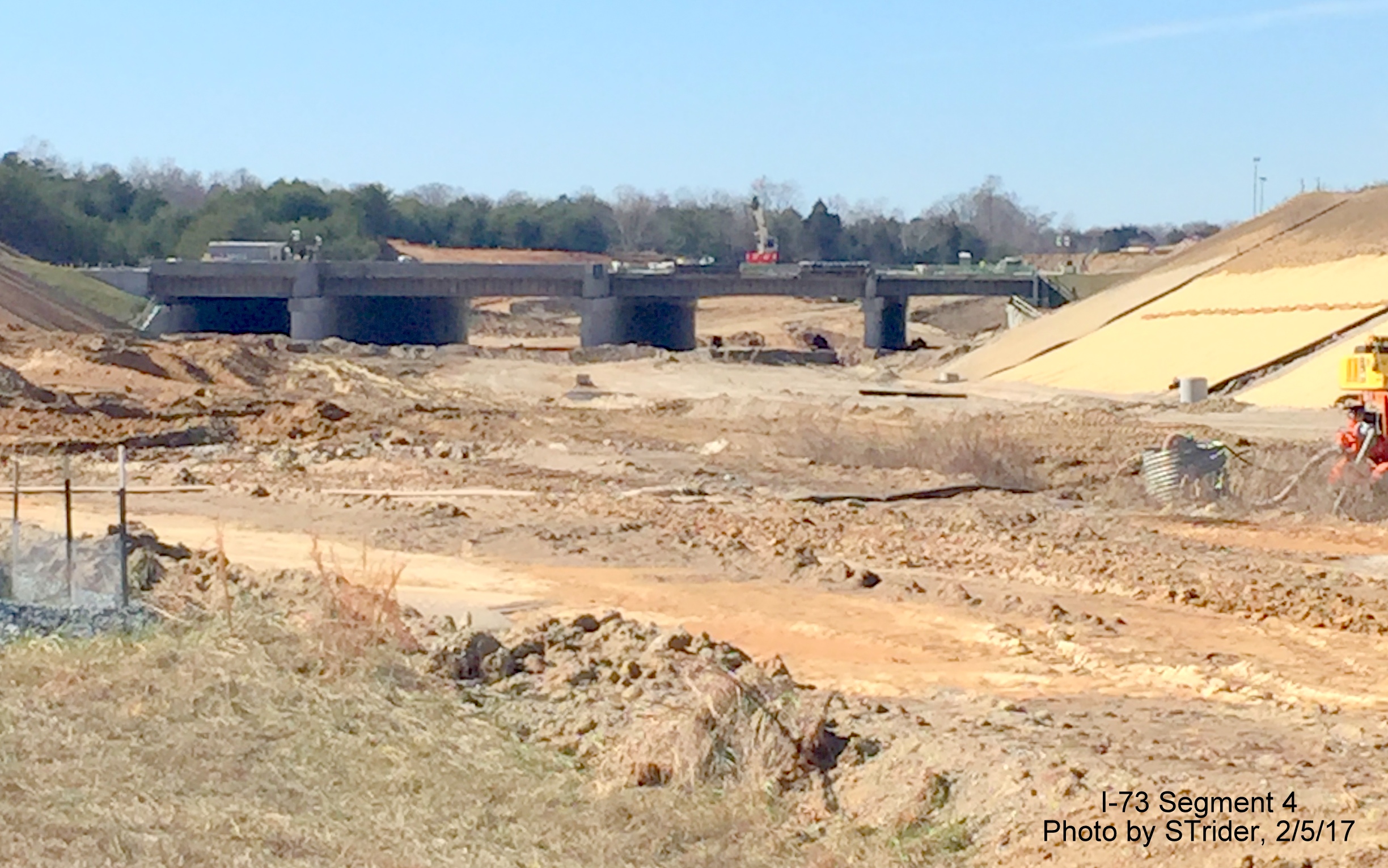 Image of view of PTI Airport Taxiway bridge being built over future I-73 lanes as seen from Bryan Blvd, from Strider