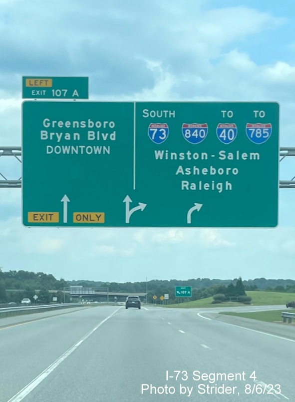 Image of overhead ramp signage for Greensboro Loop exit with new I-785 shield due to earlier 
        completion of Loop on I-73 South, photo by Strider, August 2023