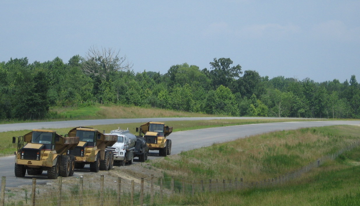 Photo of asphalt trucks parked along future I-74 westbound lanes near Poole 
Road in June 2010