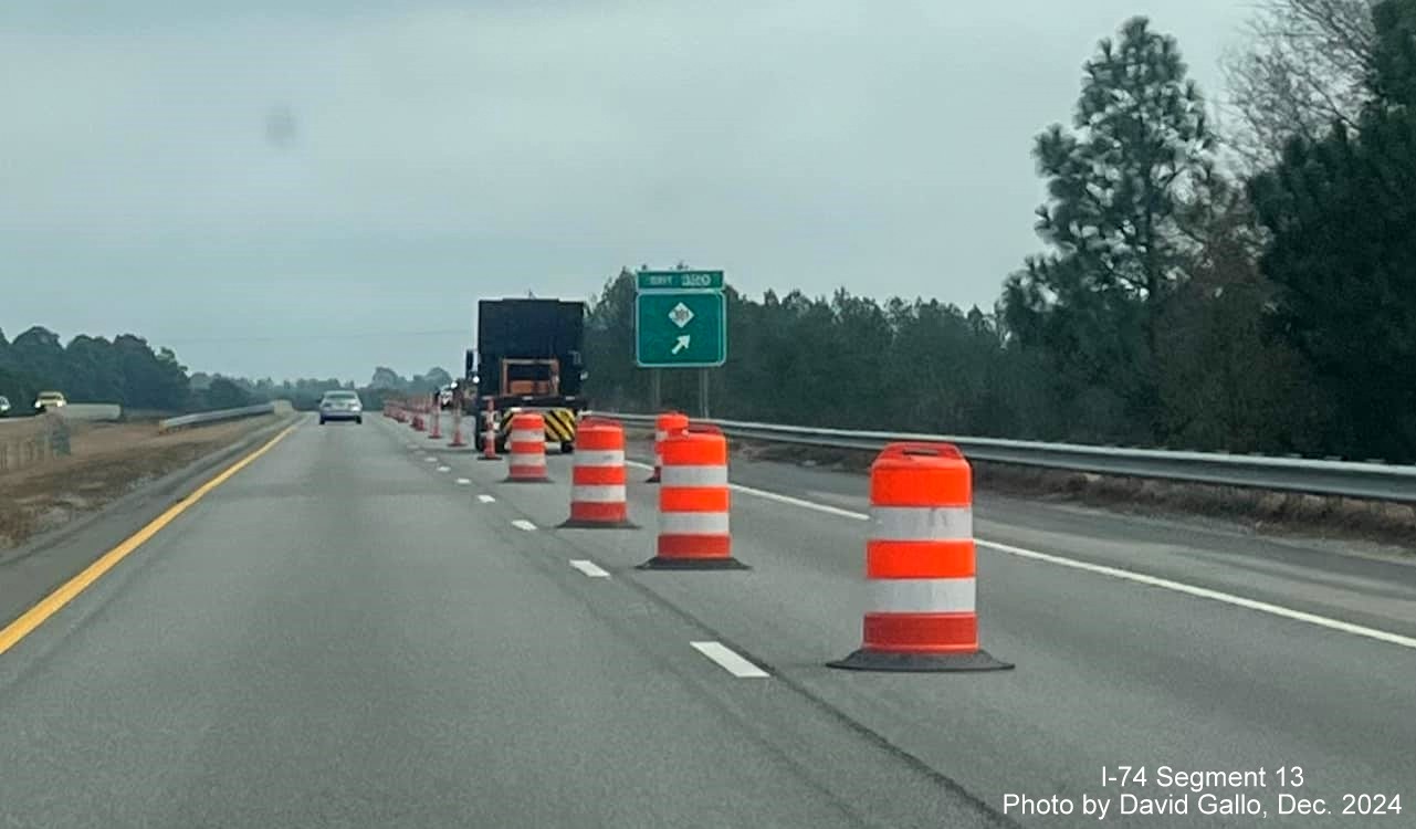 Image of new ramp sign for NC 381 exit going up in front of old sign on US 74 (Future I-74) East 
        in Hamlet, by David Gallo, December 2024