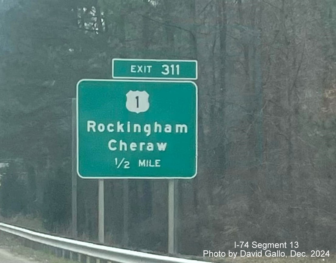 Image of new supports for a 1/2 mile advane sign for the US 1 exit going up behind the old sign on US 
        74 (Future I-74) East in Rockingham, by David Gallo, December 2024