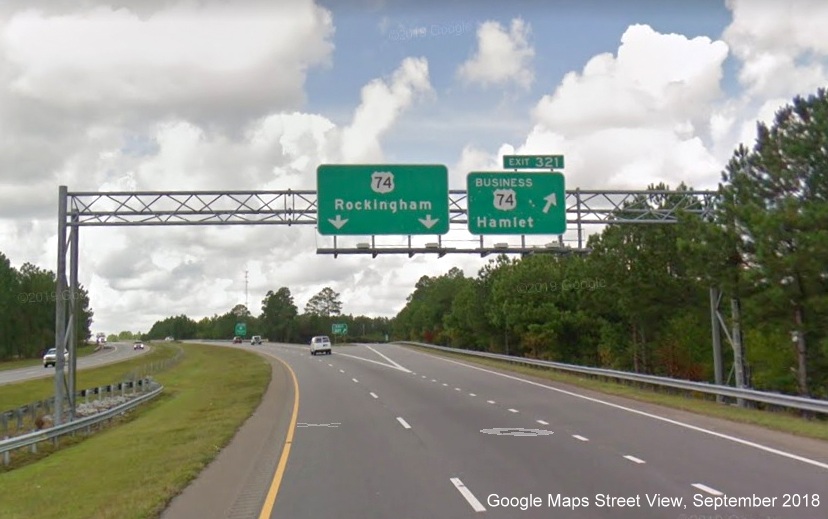 Google Maps Street View image of overhead exits signs at ramp to Business 74 West
        on US 74/Future I-74 West in Hamlet, taken in September 2018