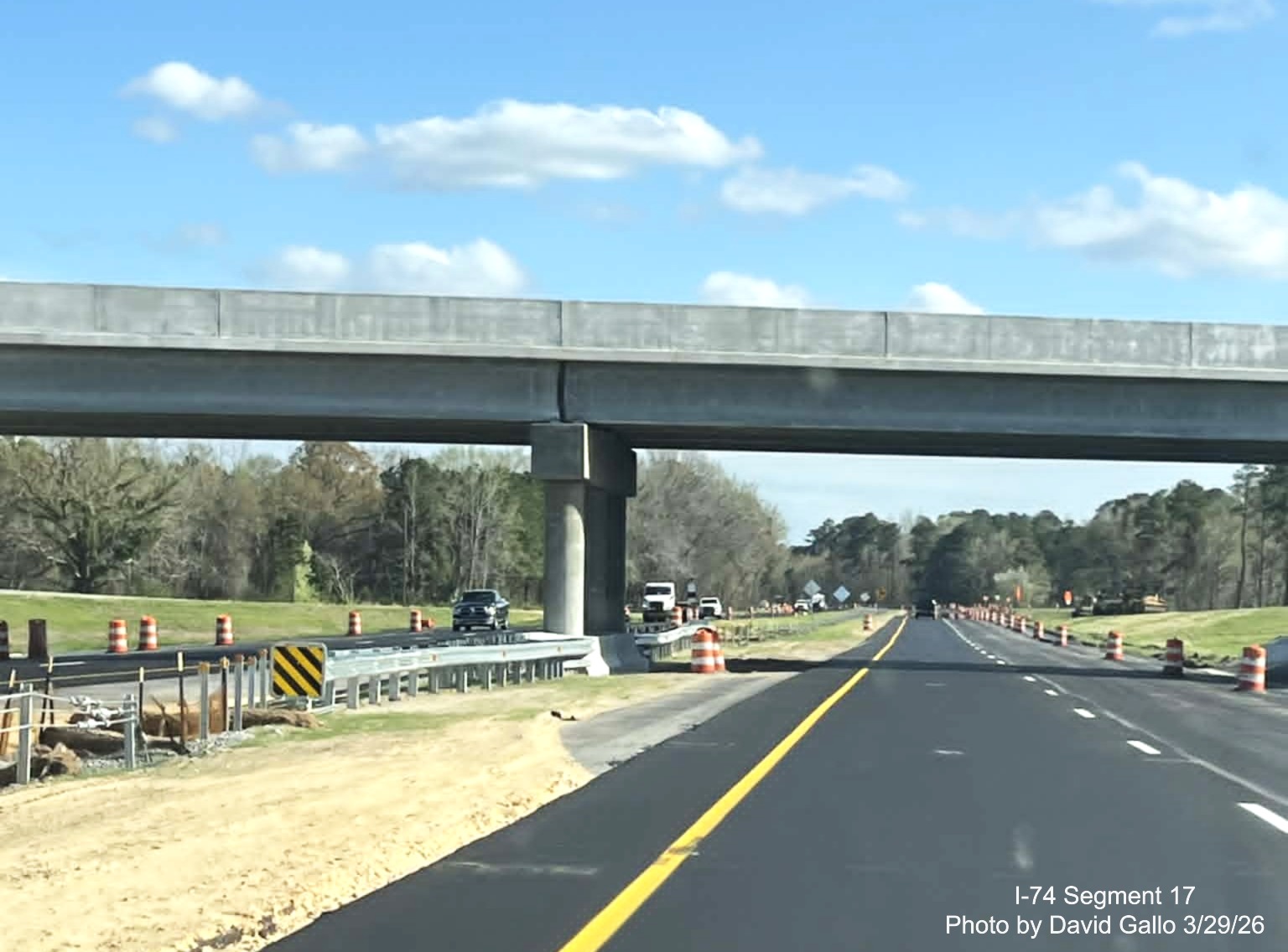 Image at the completed NC 72/ 130 West interchange bridge on US 74 
	  (Future I-74) East in Robeson County showing lane stripinc continuing along with traffic barrels, on the other side. Google 
	  Maps Street View, February 2026