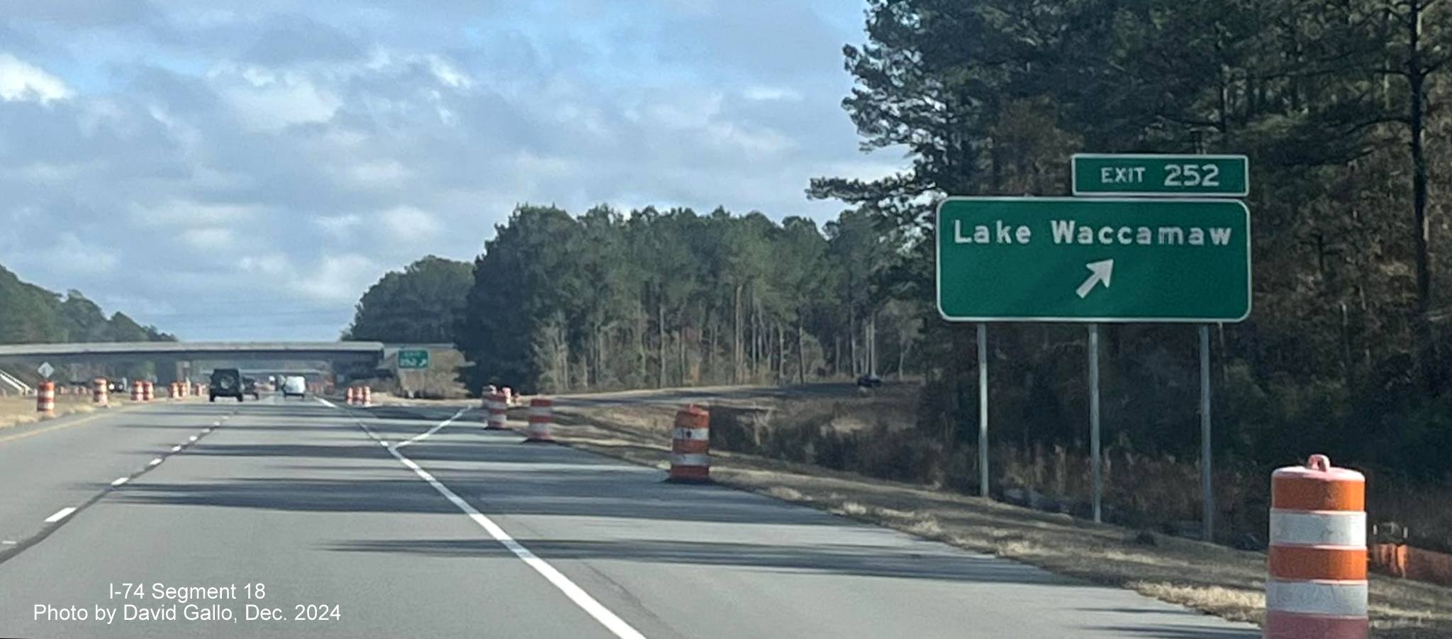 Image of recently placed ground mounted ramp and gore sign for new Lake Waccamaw exit on US 74/76 (Future I-74)
          East in Columbus County, by David Gallo, December 2024