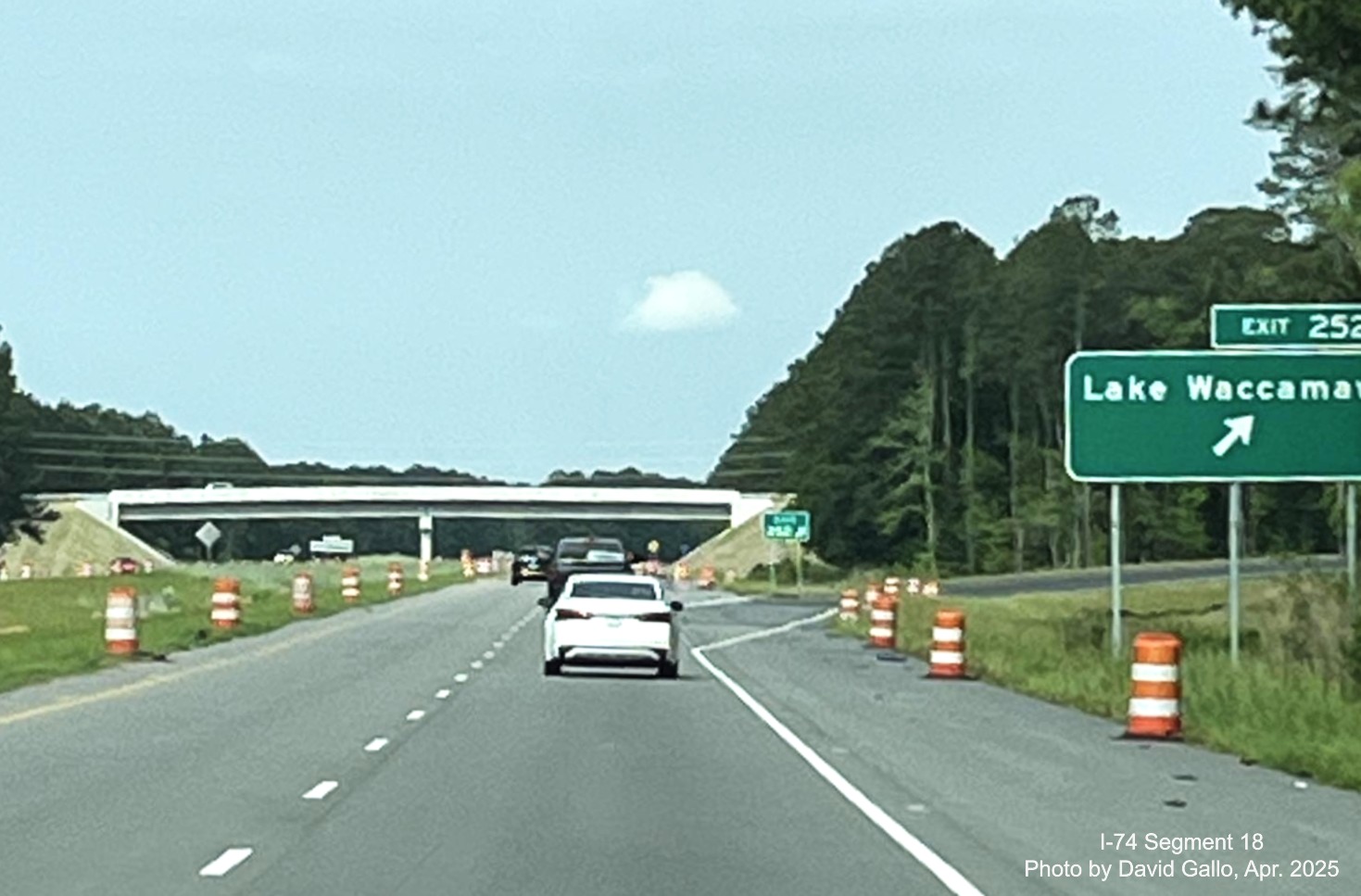 Image of recently placed ground mounted ramp and gore sign for new Lake Waccamaw exit on US 74/76 (Future I-74)
          East in Columbus County, by David Gallo, December 2024
