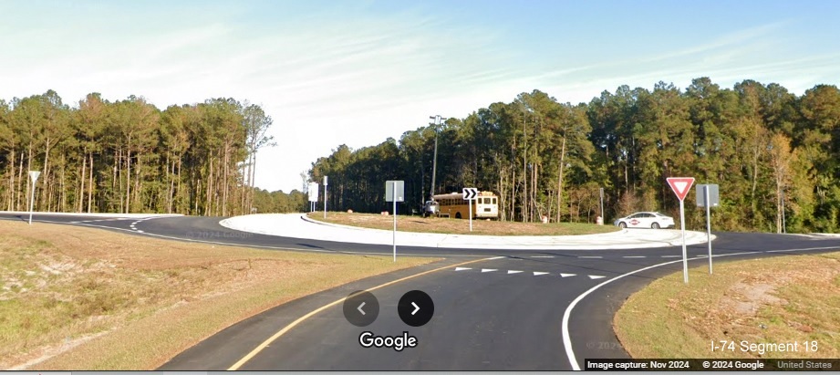 Image of entering roundabout at the end of the ramp for Lake Waccamaw exit on US 74/76 (Future I-74) 
         East, Google Maps Street View, November 2024