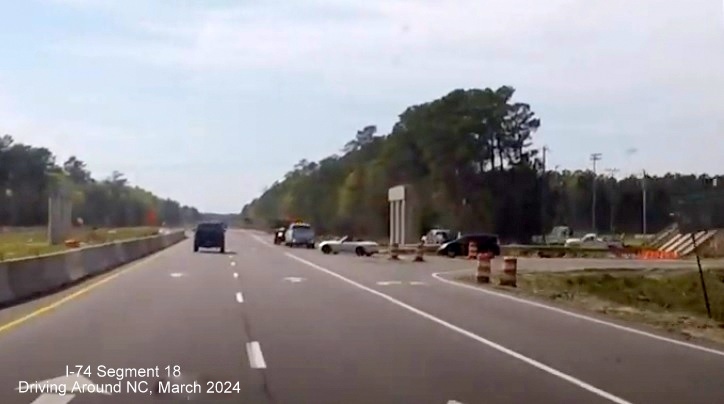 Image of piers for future Old Lake Road bridge over US 74/76 West in Lake Waccamaw construction zone, 
       screen shot from video by Driving Around NC, April 2024