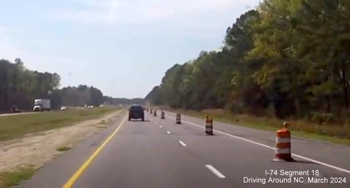 Image of US 74/76 West being reduced to 1 lane approaching future Chauncey Town Road interchange, screen 
        shot from video by Driving Around NC, April 2024