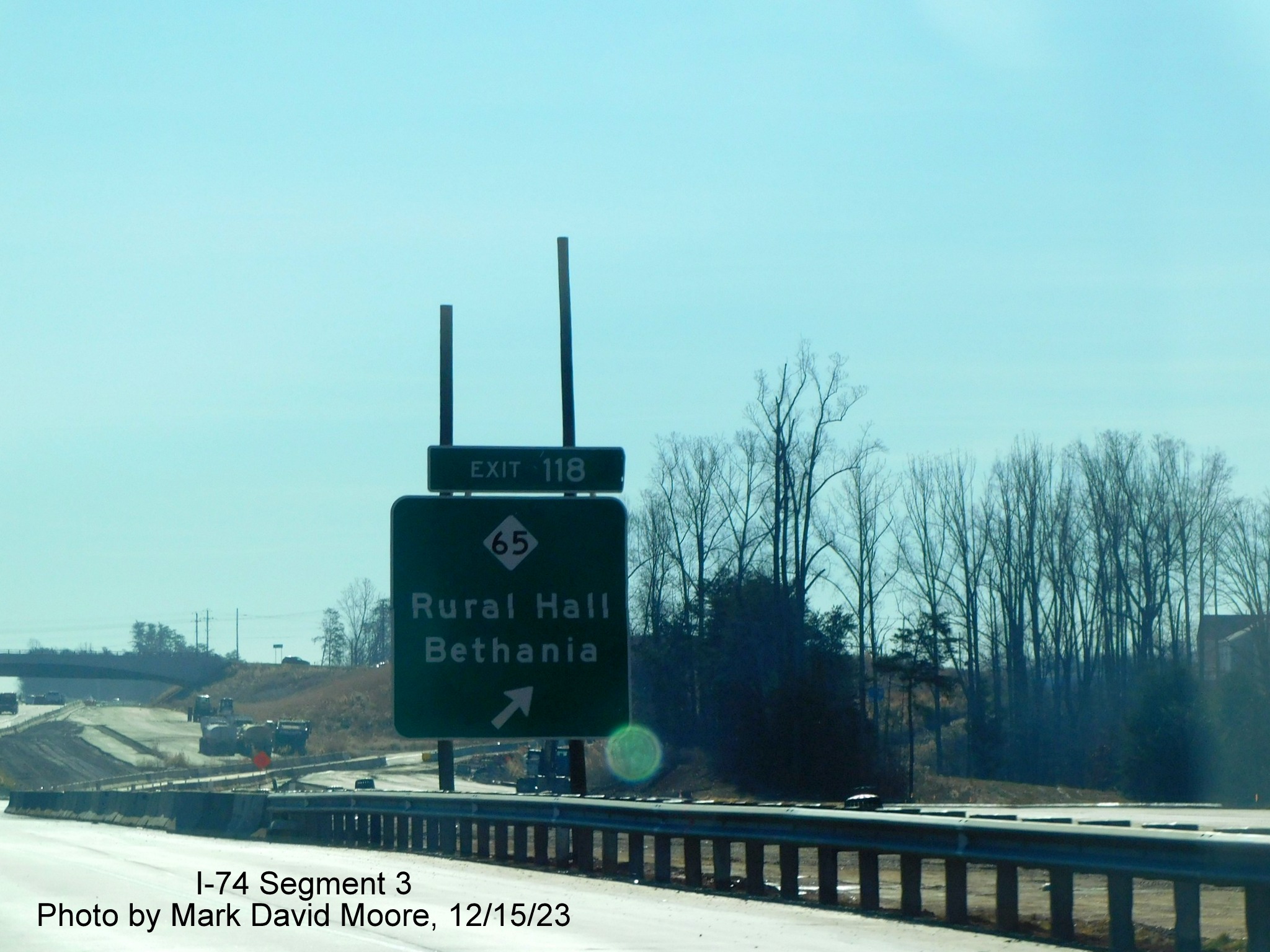 Image of ground mounted ramp sign for NC 65 exit on temporary eastbound lanes approaching the
        Winston-Salem Northern Beltway interchange in Rural Hall, by Mark David Moore, December 2023