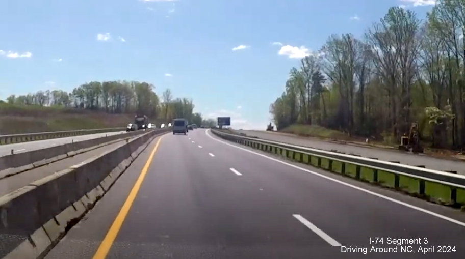 Image of ongoing paving along future US 52 South (Future I-74 East) lanes after the Westinghouse Road 
        interchange as part of Winston-Salem Beltway interchange construction project, screen grab from Driving Around NC video, April 2024