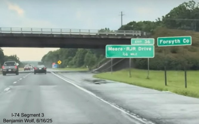 Image of renumbered 1 Mile advance sign for the Moore/RJR Drive exit on 
	  US 52 South (Future I-74 East), screen grab from Benjamin Wolf video, June 2025
