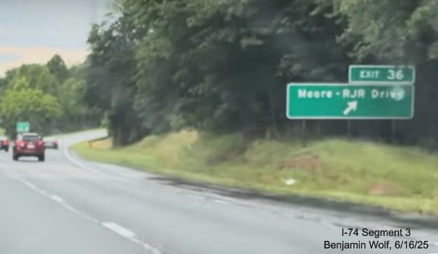 Image of renumbered ground mounted ramp sign for the Moore/RJR Drive exit on 
	  US 52 South (Future I-74 East), screen grab from Benjamin Wolf video, June 2025