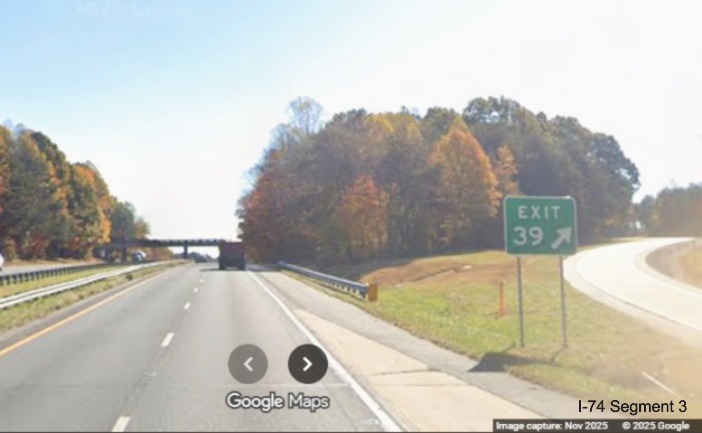 Image of renumbered ground mounted ramp sign for the Moore/RJR Drive exit on 
	  US 52 South (Future I-74 East), Google Maps Street View, November 2025