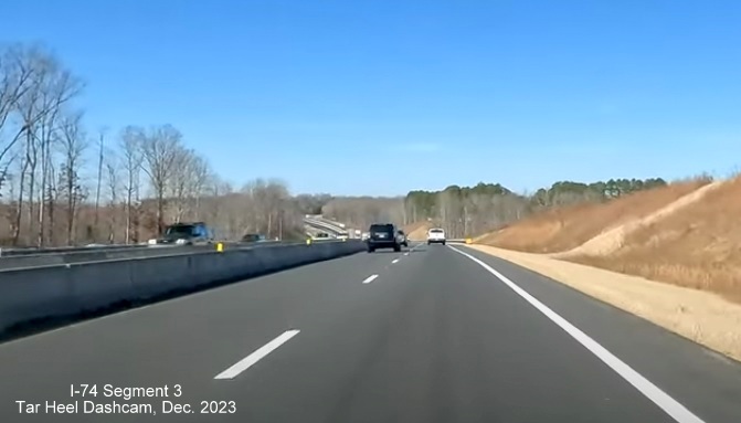 Image of driving completed lanes for US 52 North (Future I-74 West) approaching Westinghouse Road
        exit, left lane being used for US 52 South traffic, Tar Heel Dashcam, December 2023
