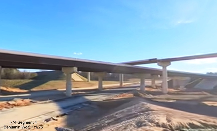 Image of flyover ramps crossing each other looking south over future I-74 Beltway
	  lanes in Winston-Salem Northern Beltway interchange project work zone, screen grab from Benjamin Wolf video, January 2026