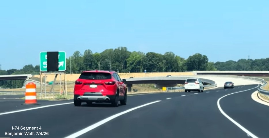 Image of gore signage at the furure NC 193 West exit at the beginning of the West 
	 I-74 Beltway lanes. Notice the lane markings have been placed for the Beltway lanes, screen grab from Benjamin Wolf video, 
	 July 4, 2026