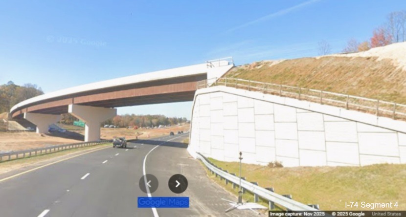 Image of from future eastbound flyover ramp bridge looking towards merge with
	  current I-74 West lanes in work zone for Winston-Salem Northern Beltway interchange, Google Maps Street View, 
	  November 2025