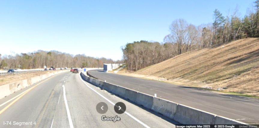 Image of paved future eastbound lanes being constructed beyond site of the future
	  Winston-Salem Northern Beltway interchange on I-74 East, Google Maps Street View, March 2025