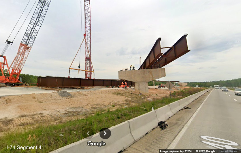 Image of steel girder being placed for future flyover ramp over I-40 East in the future
        I-74/Winston-Salem Northern Beltway interchange construction zone in Forsyth County, Google Maps Street View, April 2024