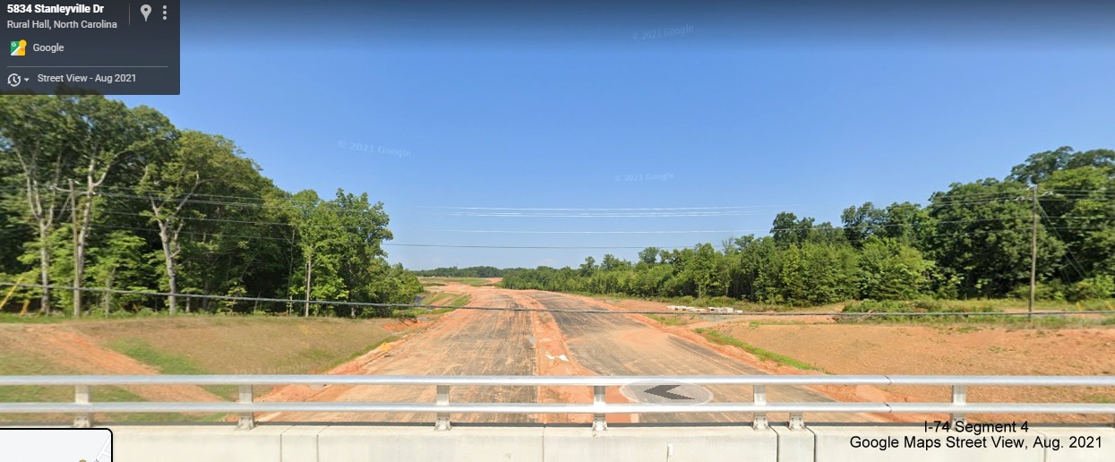 Image looking west from Stanleyville Drive bridge of future NC 74/Winston-Salem Northern Beltway roadbed partially paved, Google Maps Street View image, August 2021