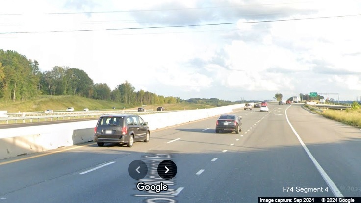 Image of temporary gore sign for NC 65 exit surrounded by construction barrels on US 52 South in 
      Winston-Salem Northern Beltway construction zone, Google Maps Street View, September 2024