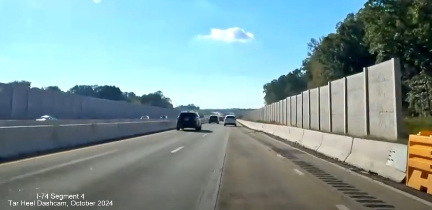 Image of completed noise wall approaching future I-74/Winston-Salem Beltway exit on 
        I-40 West near Union Cross Road, screen grab from Tar Heel Dashcam video, October 2024