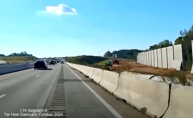 Image of noise wall under construction along future ramp to I-74/Winston-Salem Beltway exit from 
        I-40 West, screen grab from Tar Heel Dashcam video, October 2024