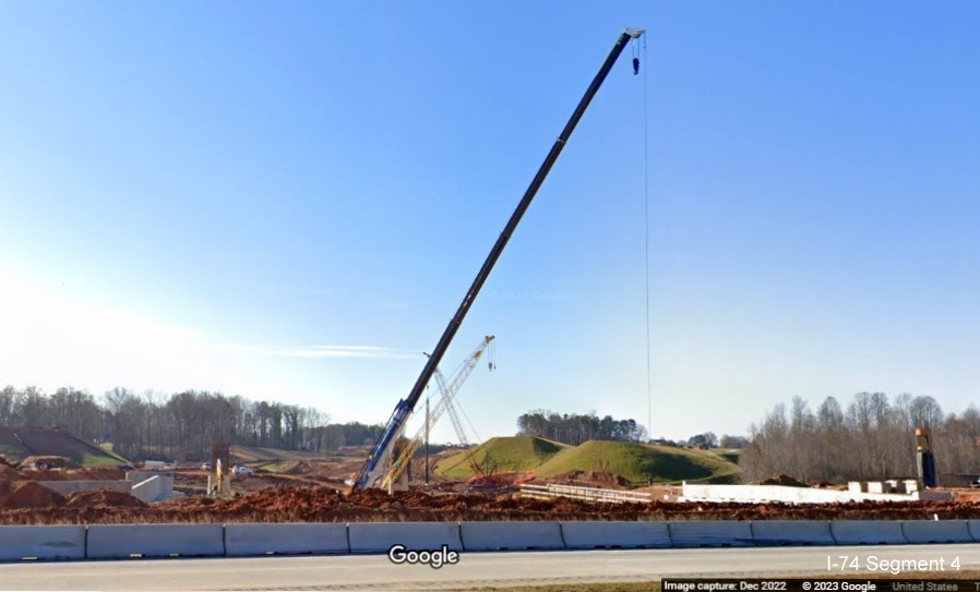 Image of crane and future ramp construction seen from I-40 West lanes for future interchange with I-74/Winston-Salem 
       Northern Beltway in Forsyth County, Google Maps Street View, December 2022