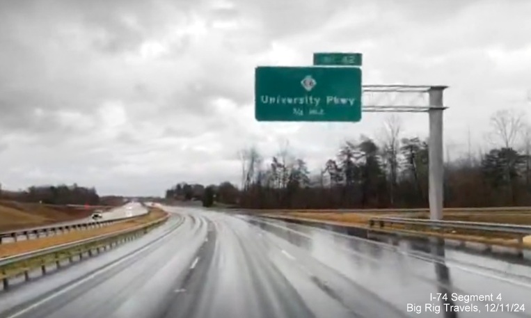 Image of newly placed 3/4 Mile advance overhead sign for NC 66/University Parkway exit on 
        completed 3 lane section of NC 74 (Future I-74) East/Winston-Salem Northern Beltway, screen grab from Big Rig Travels video, December         2024