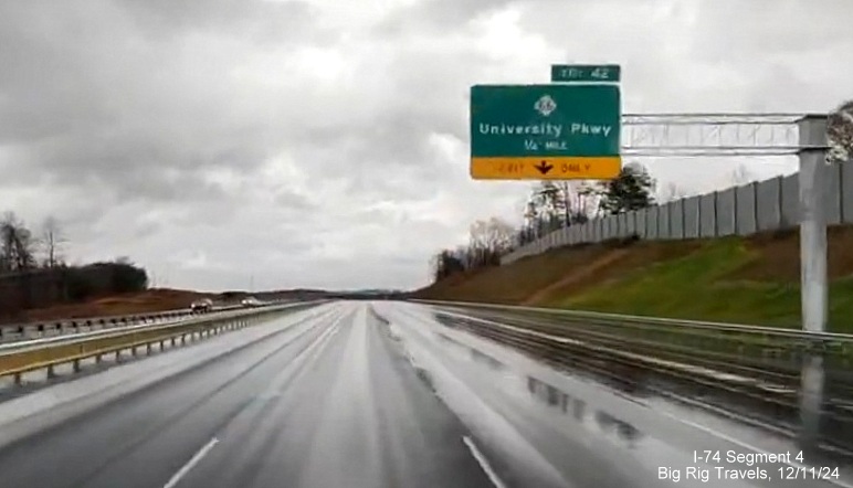 Image of newly placed 1/4 Mile advance overhead sign for NC 66/University Parkway exit on 
        completed 3 lane section of NC 74 (Future I-74) East/Winston-Salem Northern Beltway, screen grab from Big Rig Travels video, December         2024