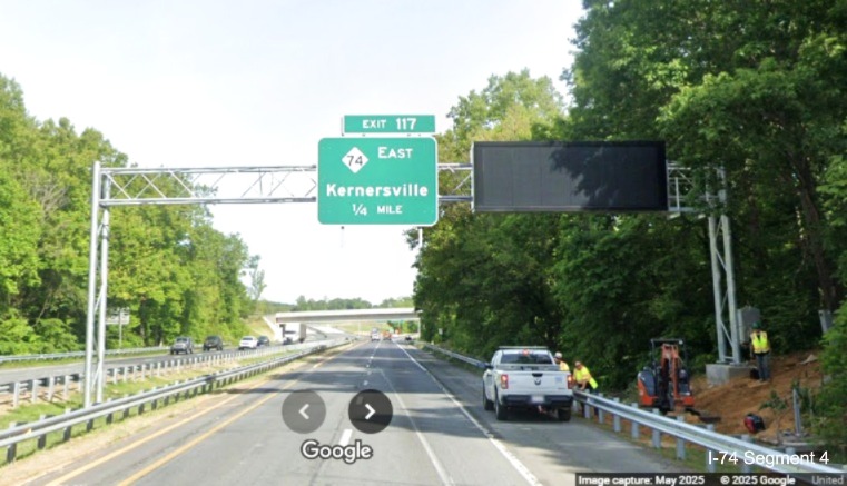 Image of workers installing a variable message sign next to 1/4 mile advance
	  overhead sign for NC 74 Winston-Salem Northern Beltway interchange on US 52 North in Rural Hall, Google Maps Street View, 
	  May 2025