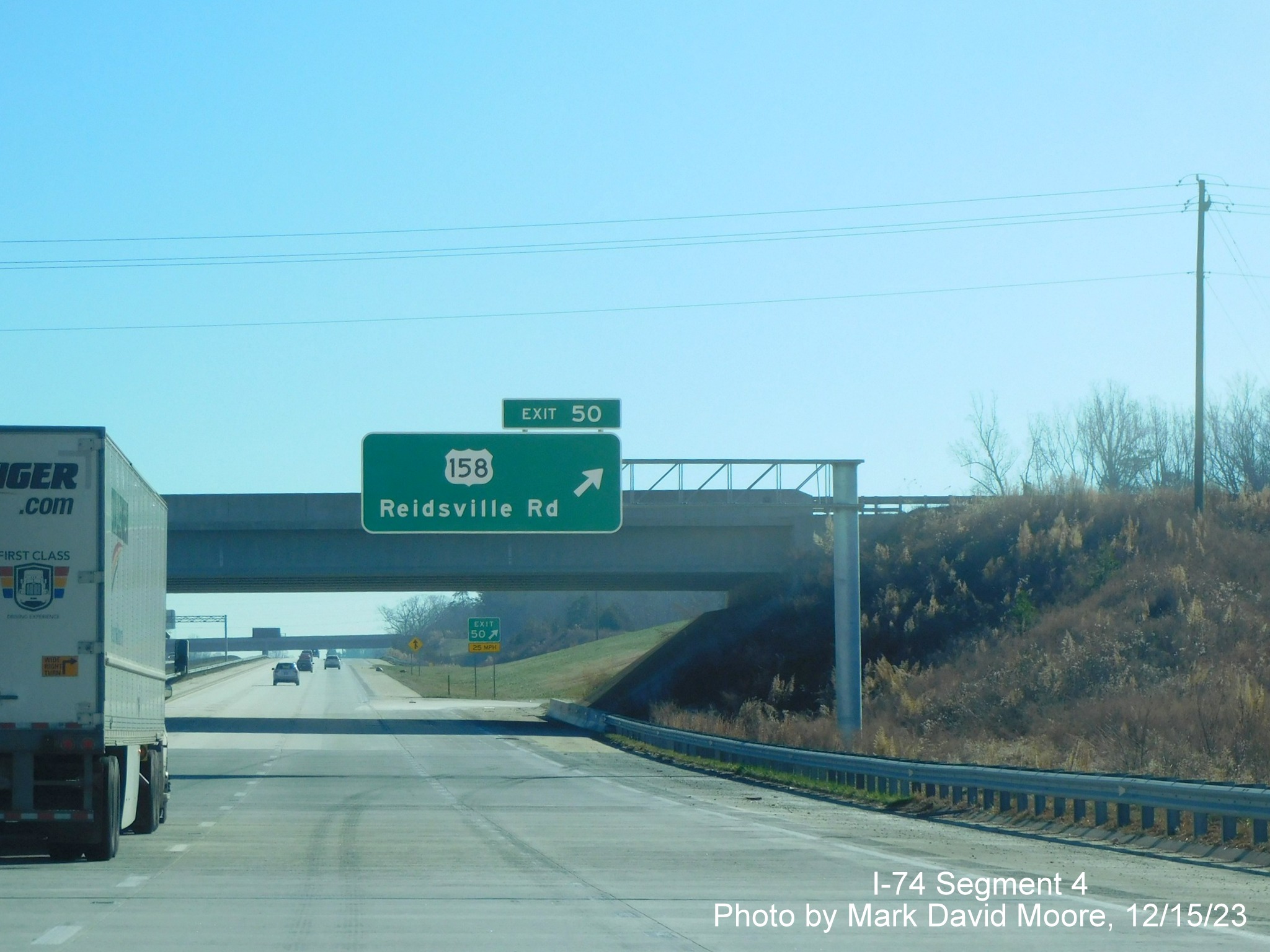 Image of overhead ramp sign for US 158 exit on NC 74 (Future I-74) East/
        Winston-Salem Northern Beltway, by Mark David Moore, December 2023