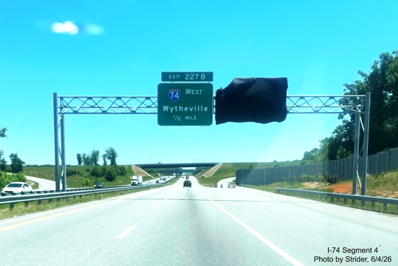 Image of new I-74 West 1/2 Mile advance sign and covered over I-74 East ramp sign
	  on US 421 East at the Beltway, photo by Strider, June 2026