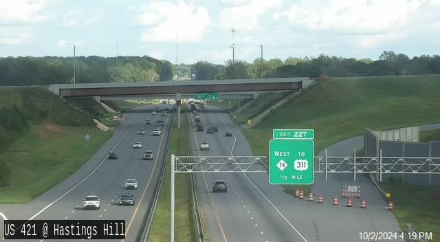 Image of 1/2 mile advance overhead sign for NC 74 East unchanged with end point listed at US 311, 
       NCDOT, October 2024