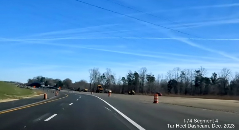 Image of NC 74 (Future I-74) East lanes using future westbound lanes approaching ramps being 
        contructed from US 52 North, from video by Tar Heel Dashcam, December 2023