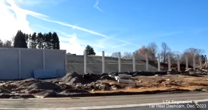 Image of noise wall construction at end of future ramp from I-74 West/Winston-Salem Northern
        Beltway exit to I-40 East, from video by Tar Heel Dashcam, December 2023