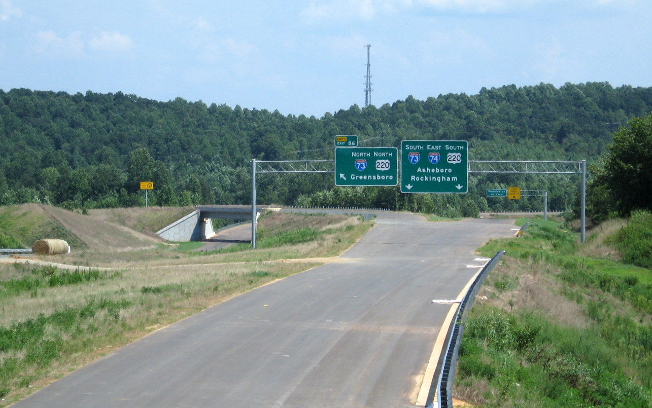 Photo of view south of Heath Dairy Road Bridge showing overhead signs now in 
place for US 220 interchange (Exit 86) on future I-74 freeway near Randleman, July 2012