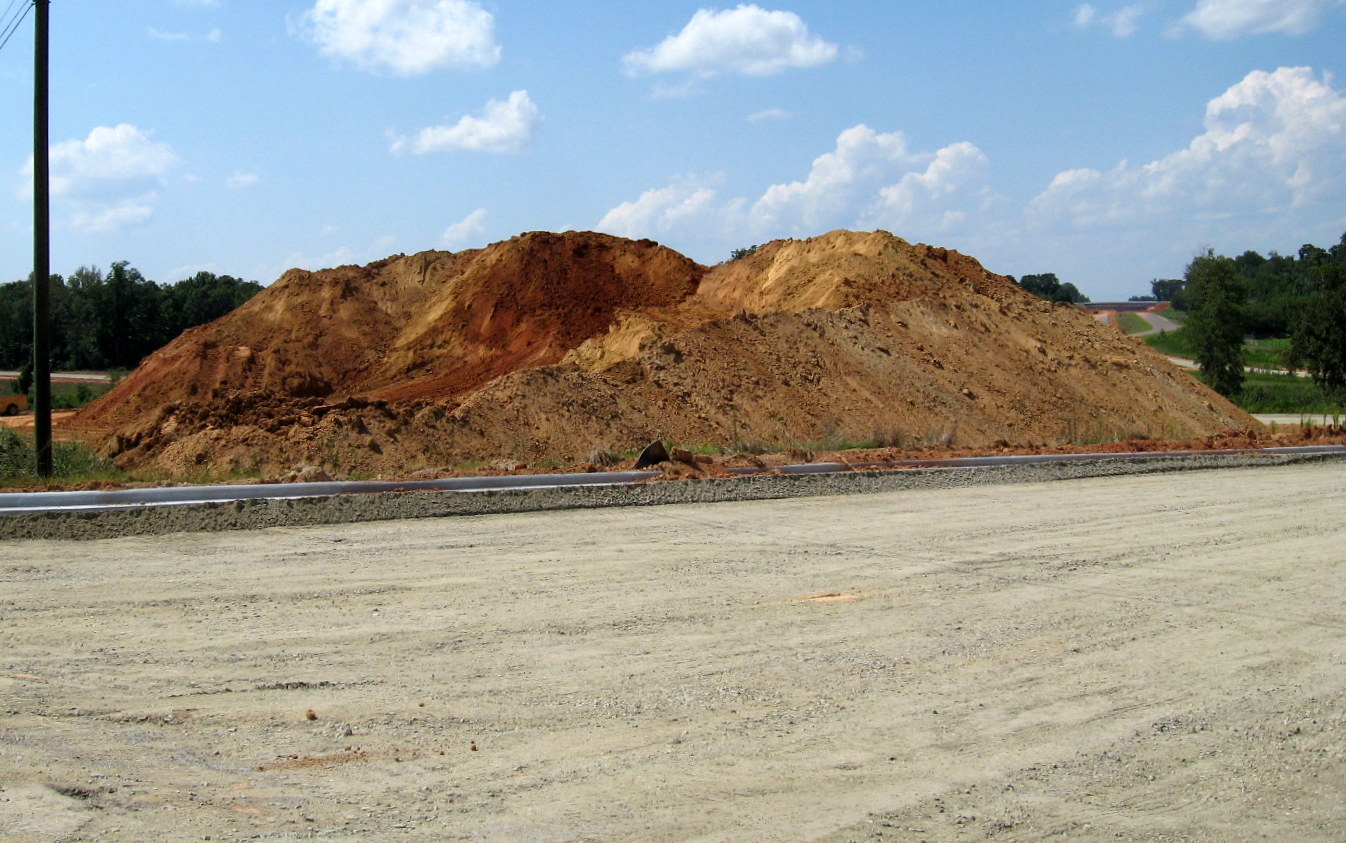 Photo of large dirt piles placed at future US 311 interchange area from soils 
excavated for future I-74 freeway