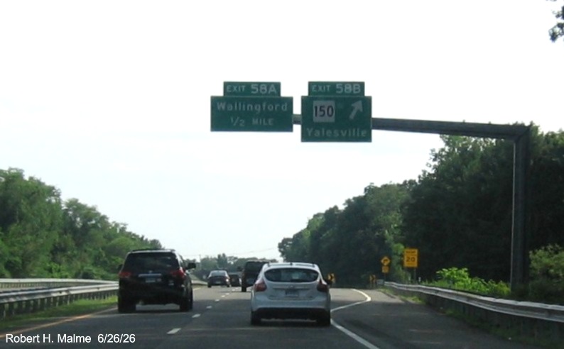 Image of overhead signage at ramp for CT 150, with new milepost based exit number overlays on 
 exit tabs on CT 15 South/Cross Parkway in Wallingford, June 2026