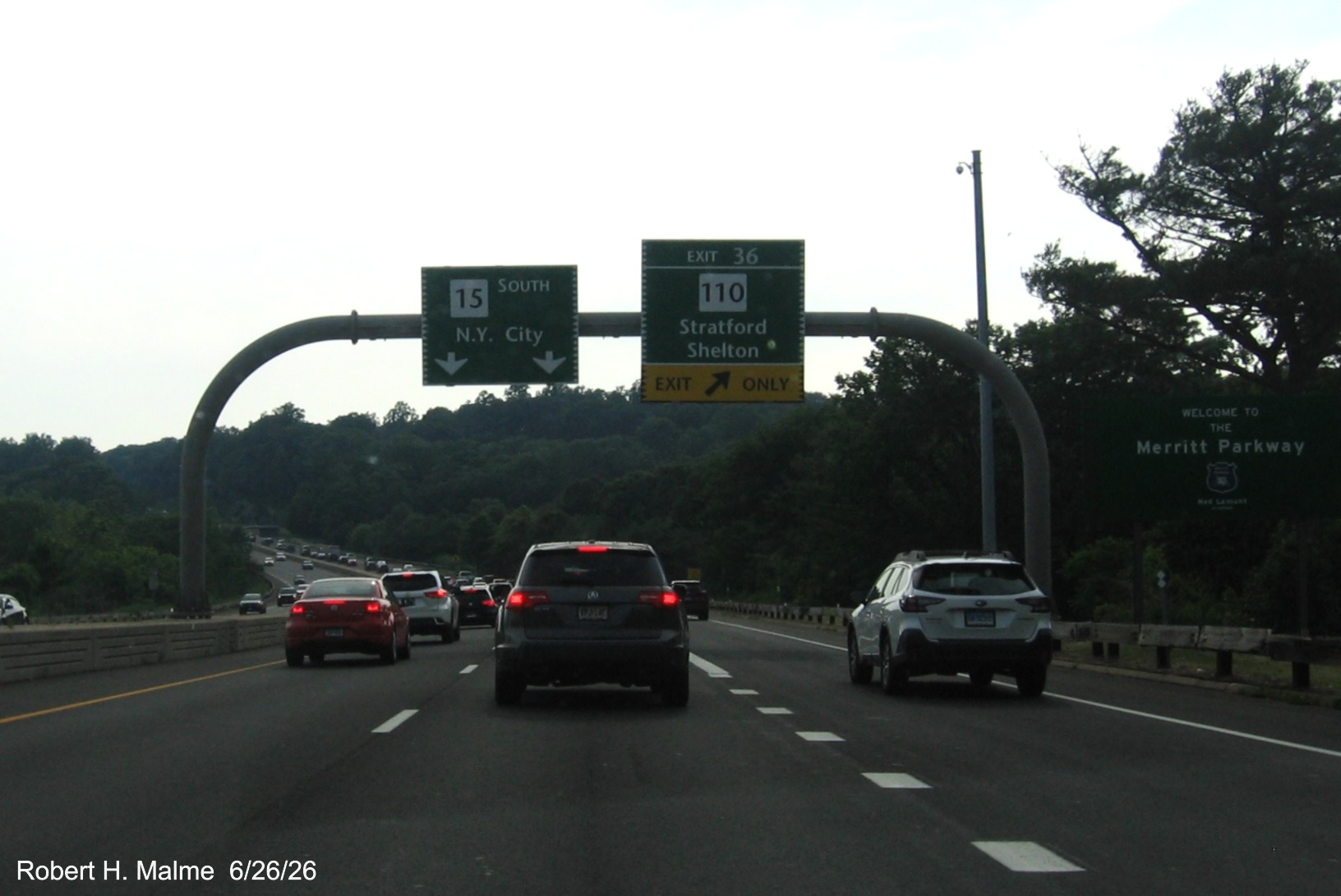 Image of overhead ramp sign for the CT 110 exit, with new milepost based exit 
 number and Welcome to the Merritt Parkway sign on CT 15 South/Merritt Parkway in Stratford, June 2026