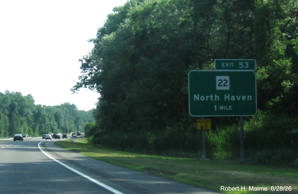 Image of new ground mounted 1 Mile advance sign for the CT 22 exit, now with 
 new milepost based exit number and a yellow Old Exit 63 sign on support post on CT 15 South/Cross Parkway in North Haven, 
 June 2026