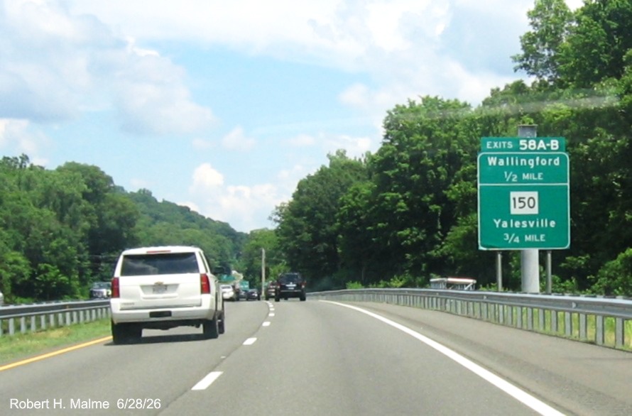 Image of ground mounted advance sign for the Wallingford and CT 150 exits, with
 new milepost based exit number overlays on exit tab on CT 15 North/Cross Parkway in Wallingford, June 2026